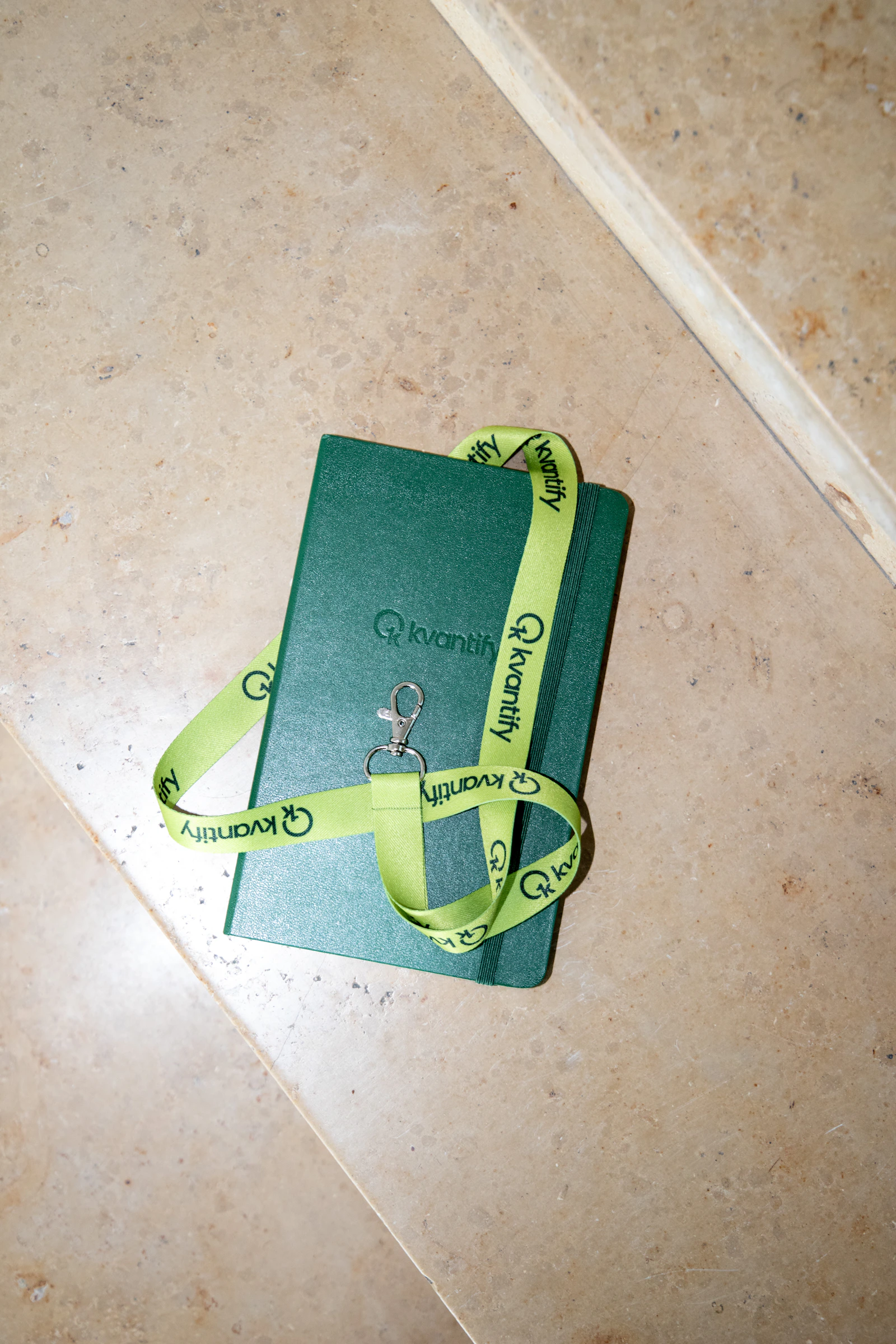 Custom branded green notebooks for Kvantify's company merchandise