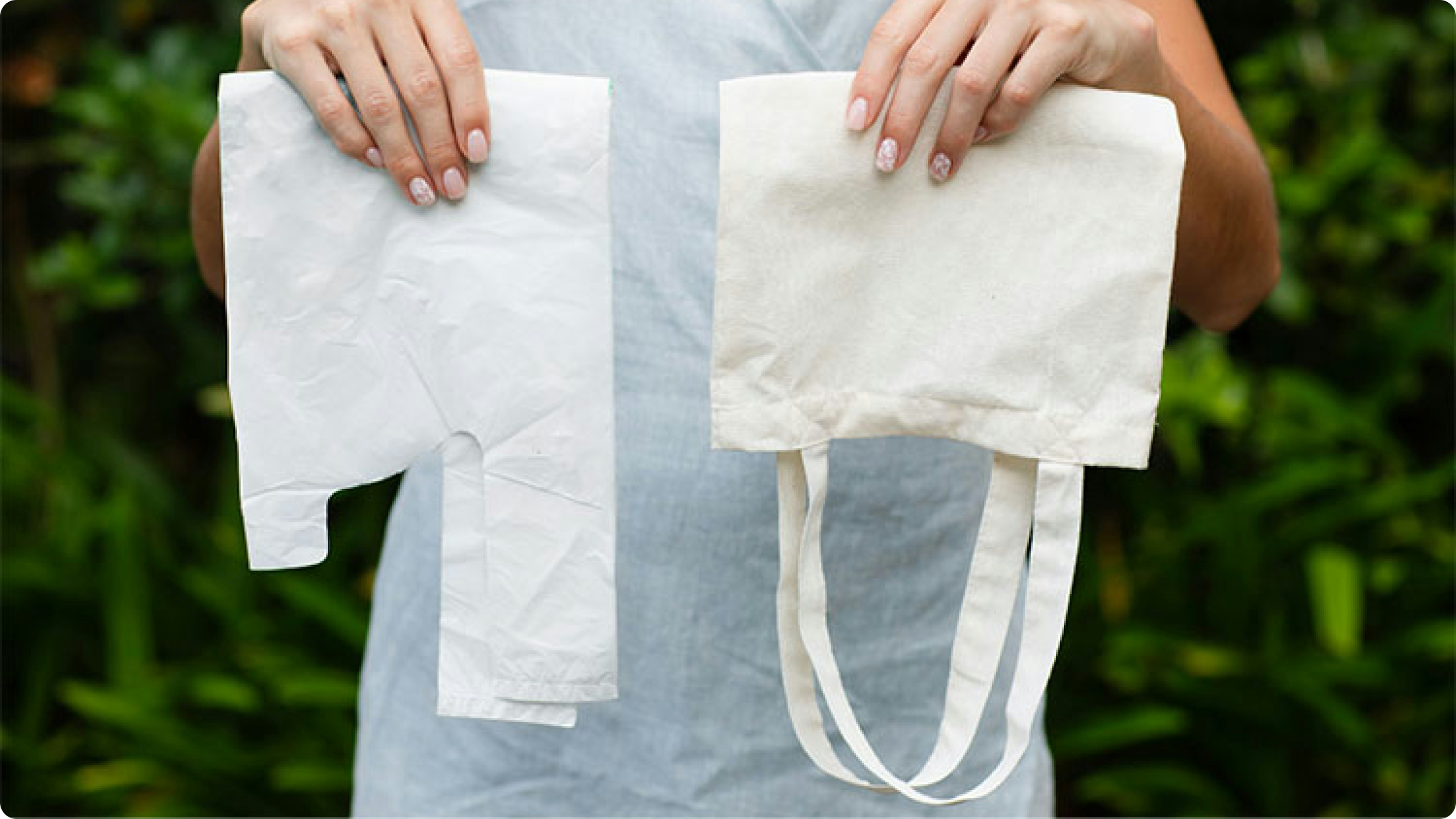 Hands holding a plastic bag next to a reusable cotton tote bag