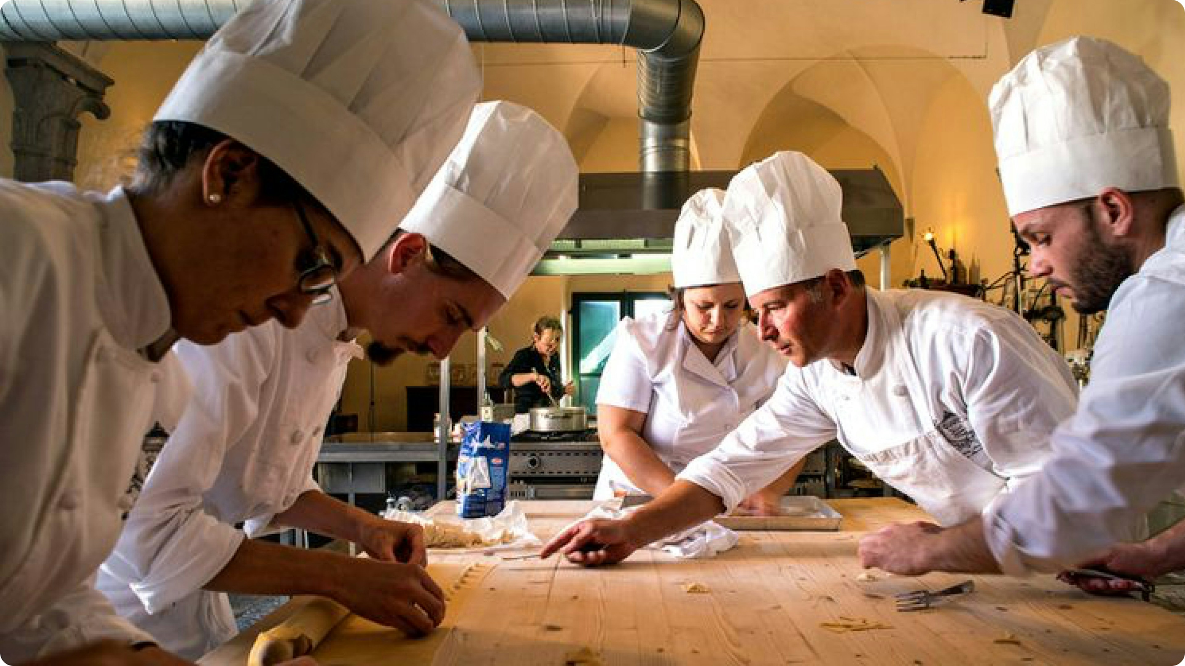 Team cooking class scene, people preparing pasta together in a kitchen